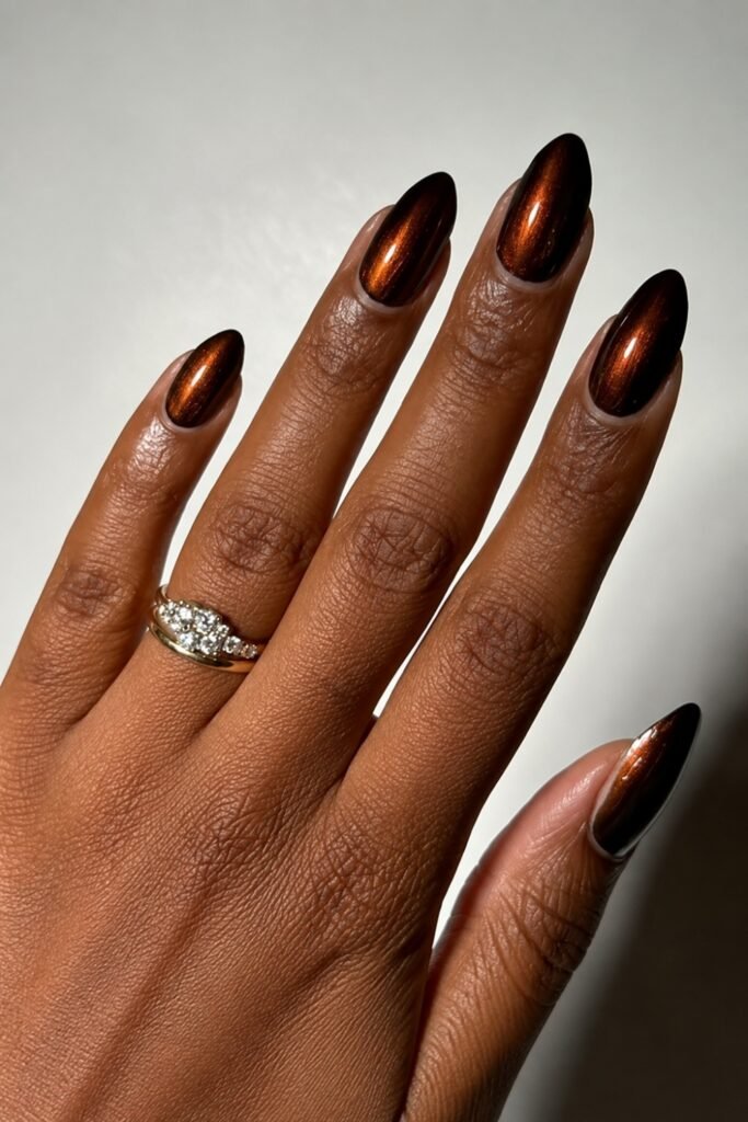 Espresso chrome almond nails with an engagement ring