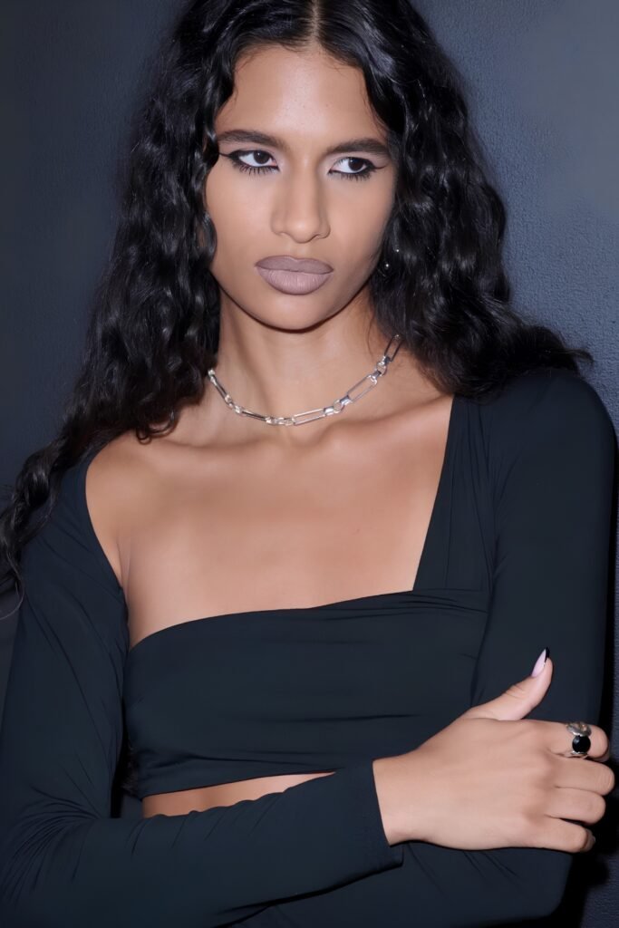 Long dark wavy hair and minimal greige makeup worn with a black top