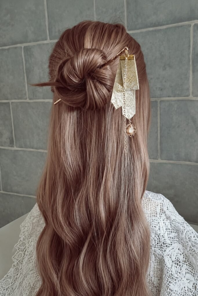 Back view of a half-up bun with a statement hair pin and long waves