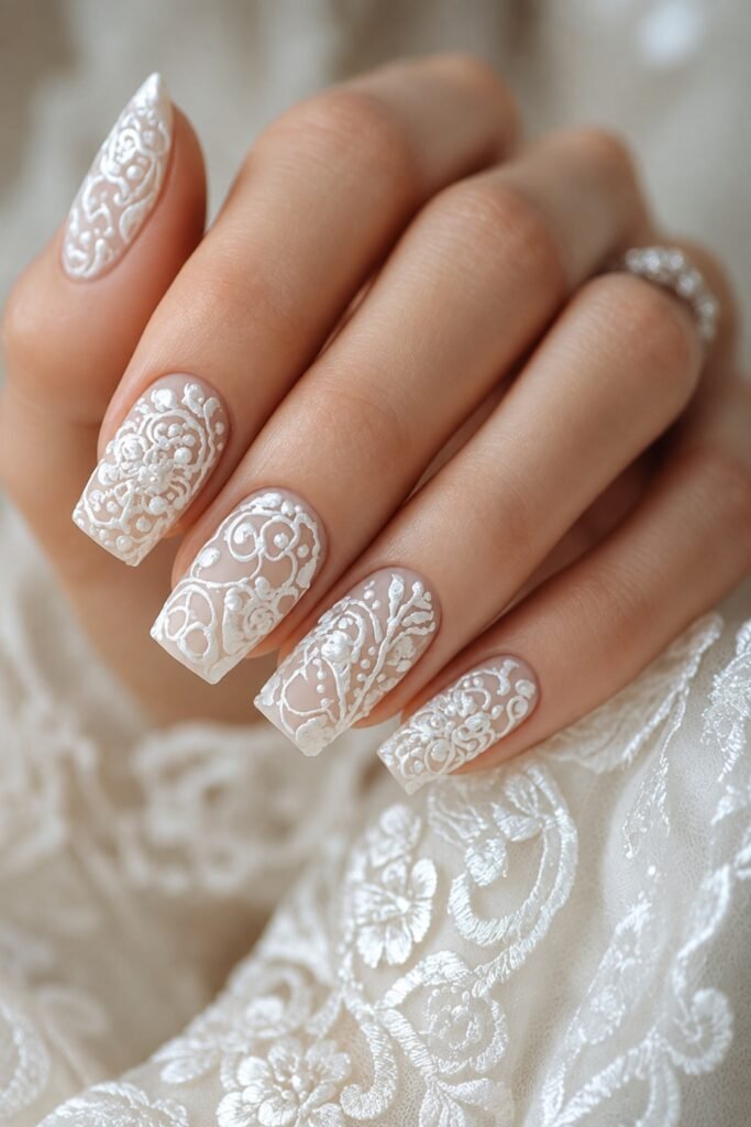 Lace-inspired white nail art on almond nails