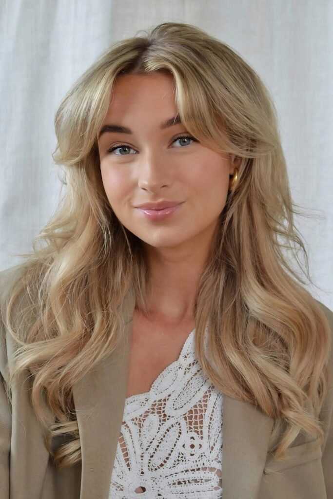 Woman with long blonde hair and soft curtain bangs