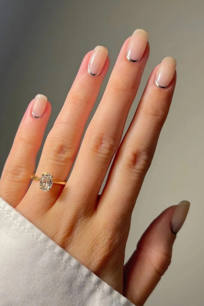 Micro-French nails with a fine silver detail and a ring