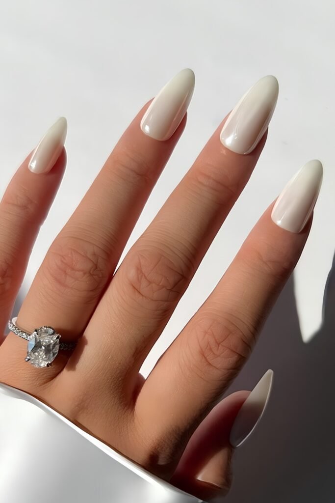 Milky almond nails with a diamond engagement ring