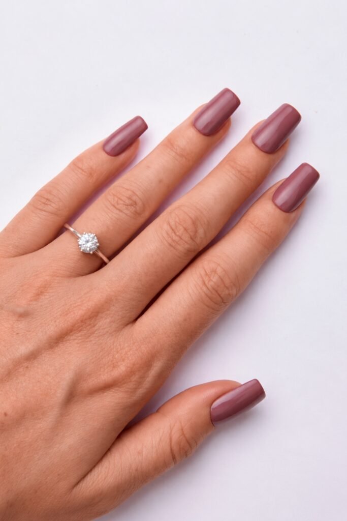 Muted mauve nails with a diamond ring