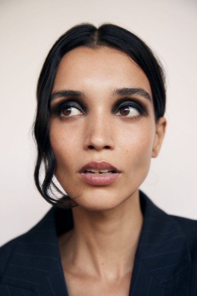 Slicked-back dark hair with soft smoky shadow and no eyeliner