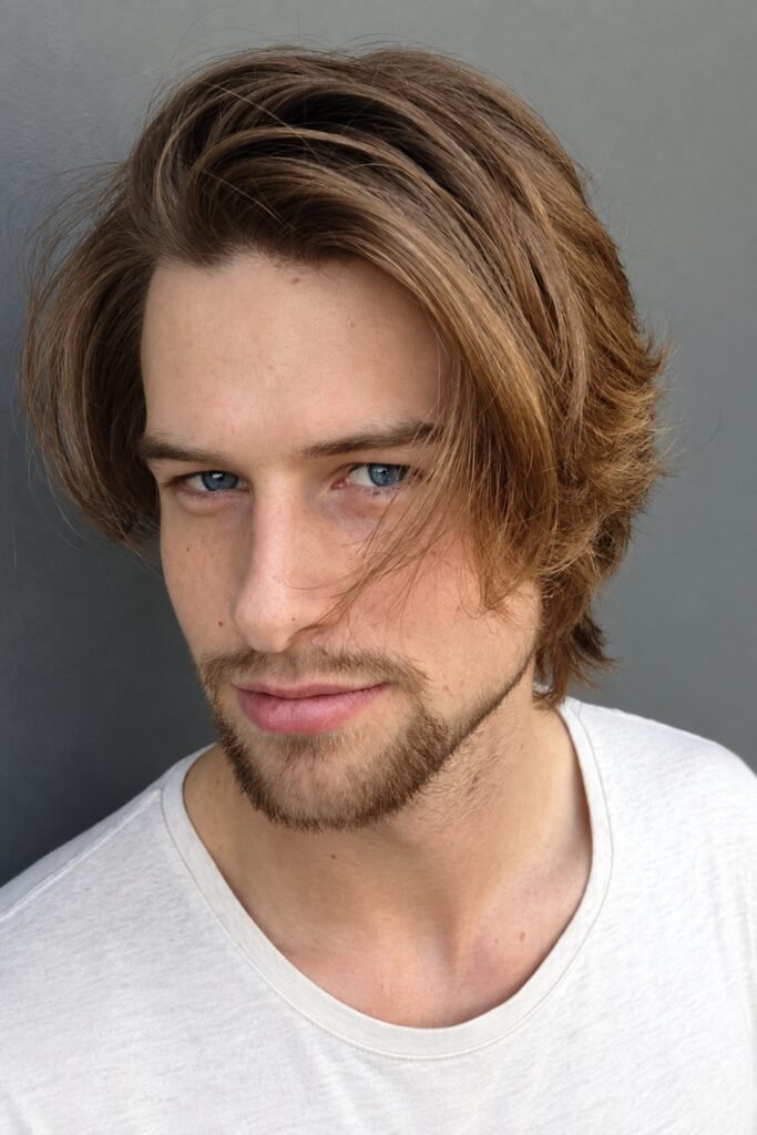 Man with an off-center flow haircut and long bangs