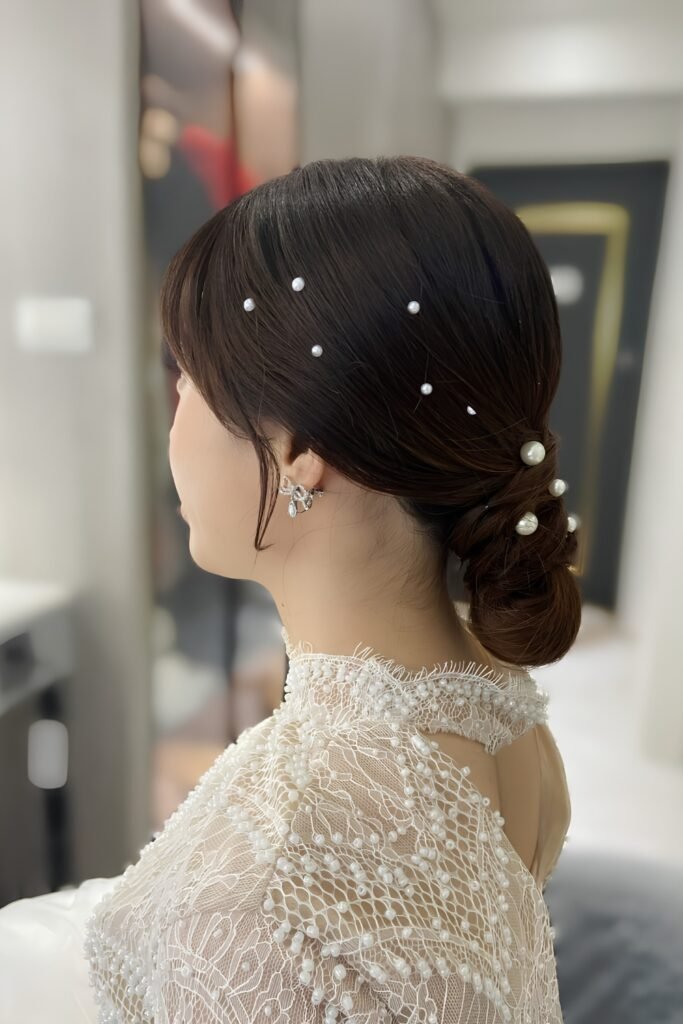 Back view of a low bun decorated with pearl pins