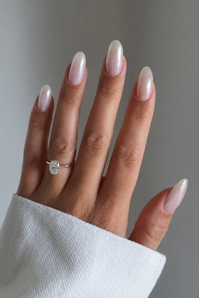 Pearl chrome glazed almond nails with an engagement ring