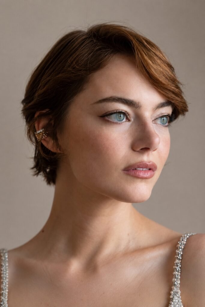 Woman with a polished auburn pixie and a side fringe