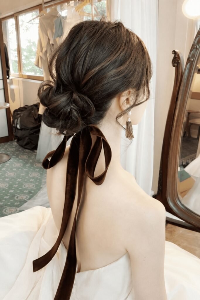Back view of a low bun tied with a long dark ribbon
