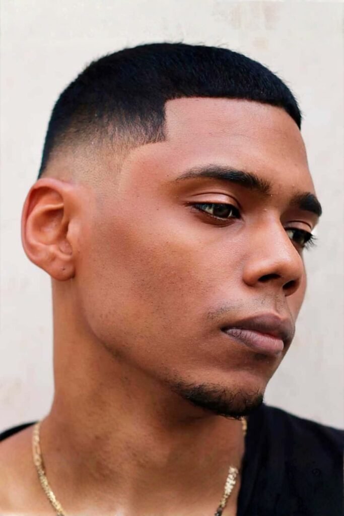 Buzz cut with a skin fade and a sharp line-up on dark hair