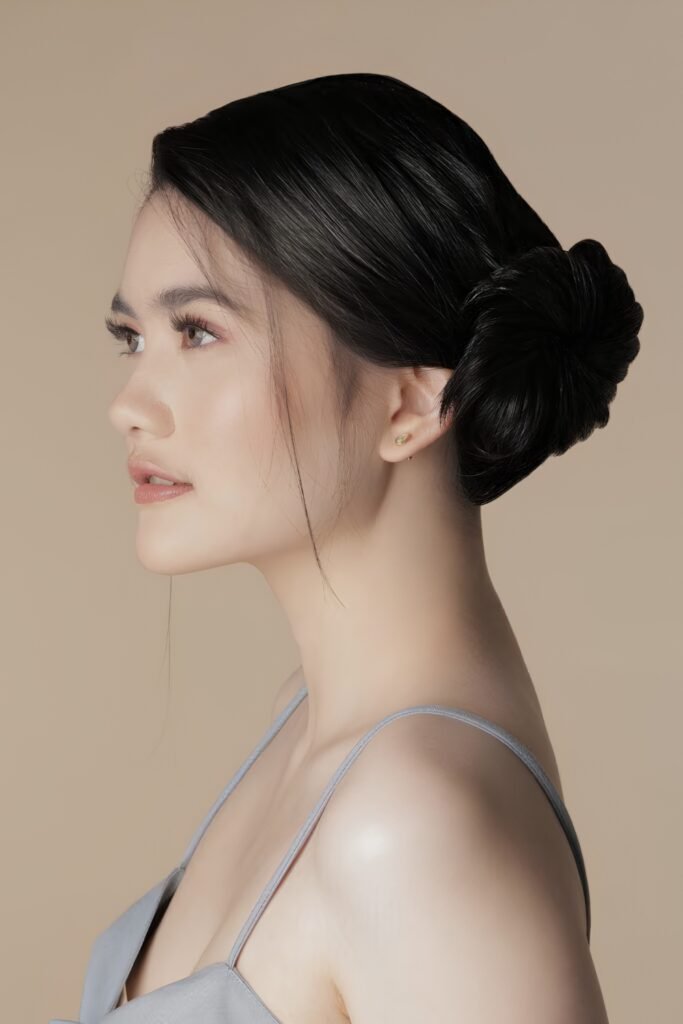 Side profile of a soft side-part low bun