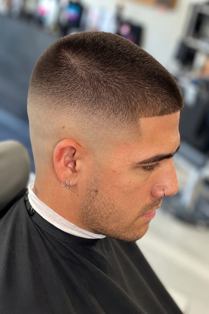 Buzz cut with a taper fade seen from the side in a barbershop