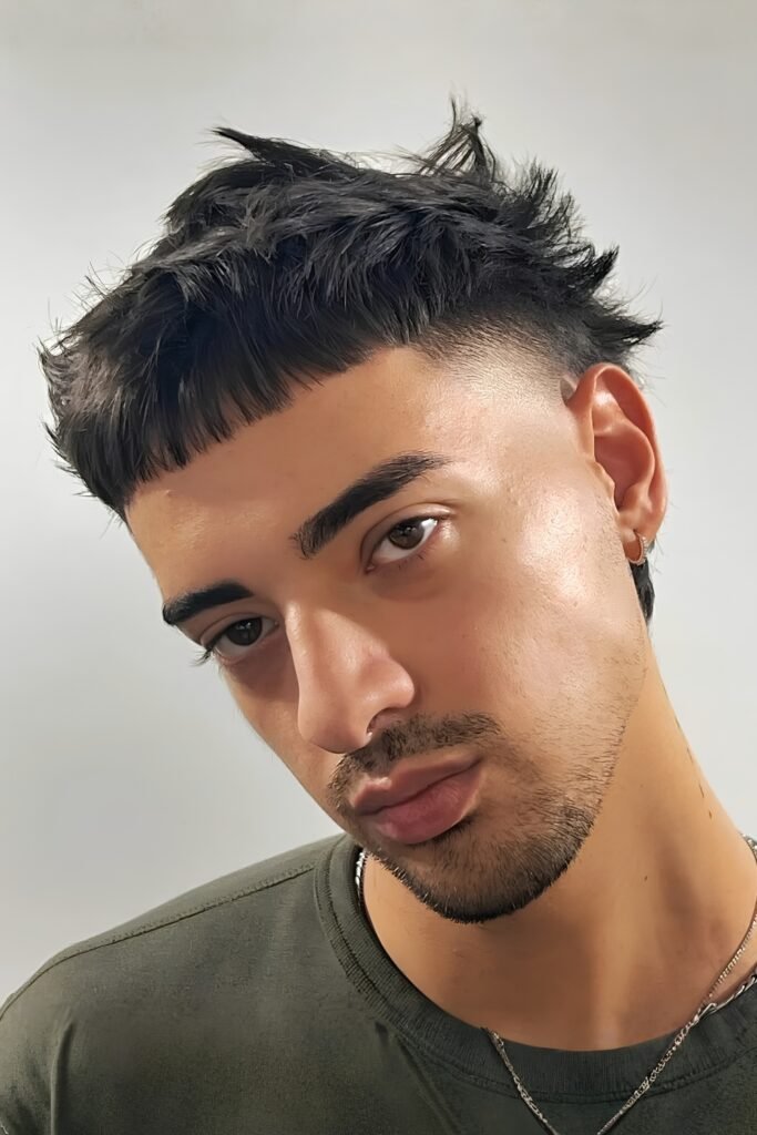 Textured crop haircut on a man with thick eyebrows