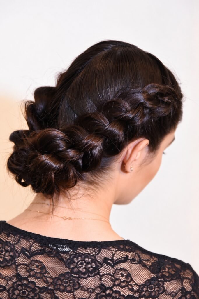 Back view of a dark braided low bun with a lace neckline