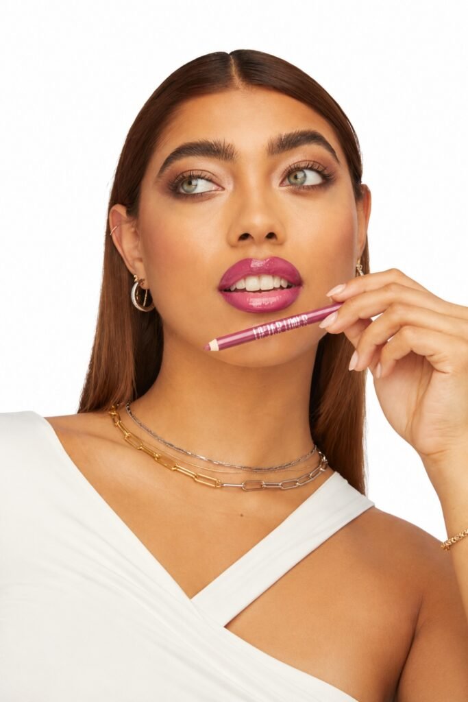 Woman applying a high-shine nude gloss over brown liner