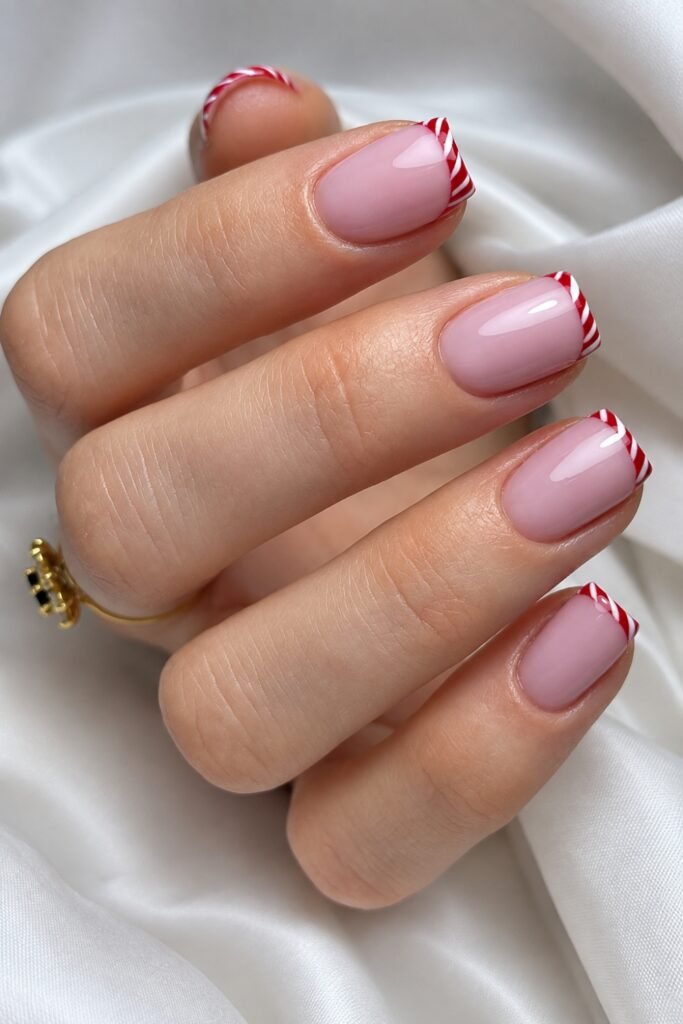 Short square pink nails with red and white candy cane tips