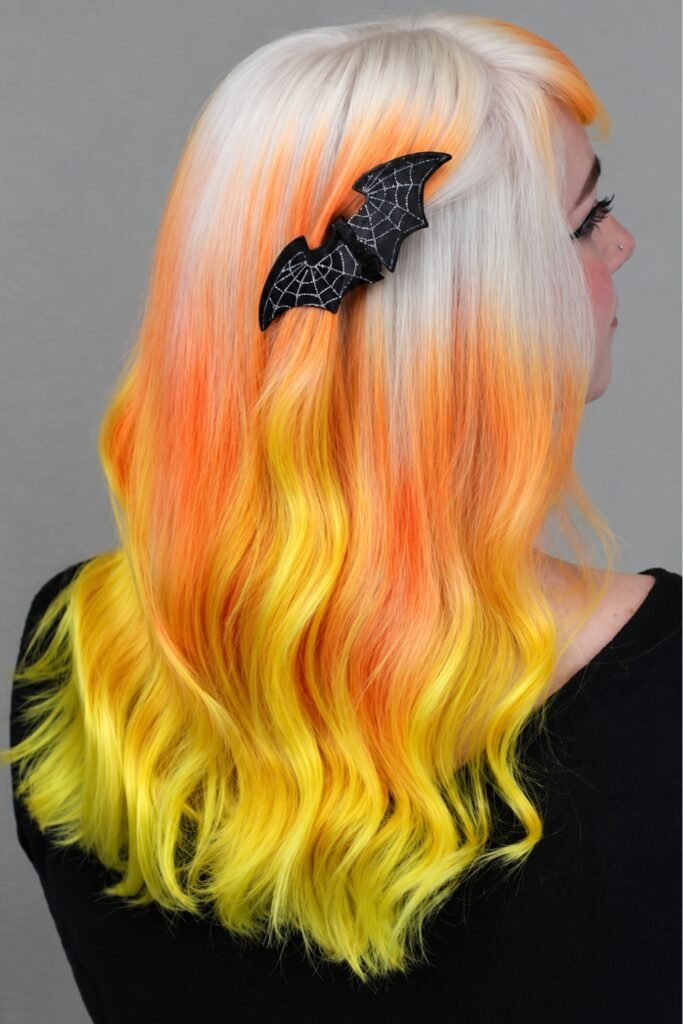 Wavy hair in cream blonde, orange and yellow blocks with a bat clip