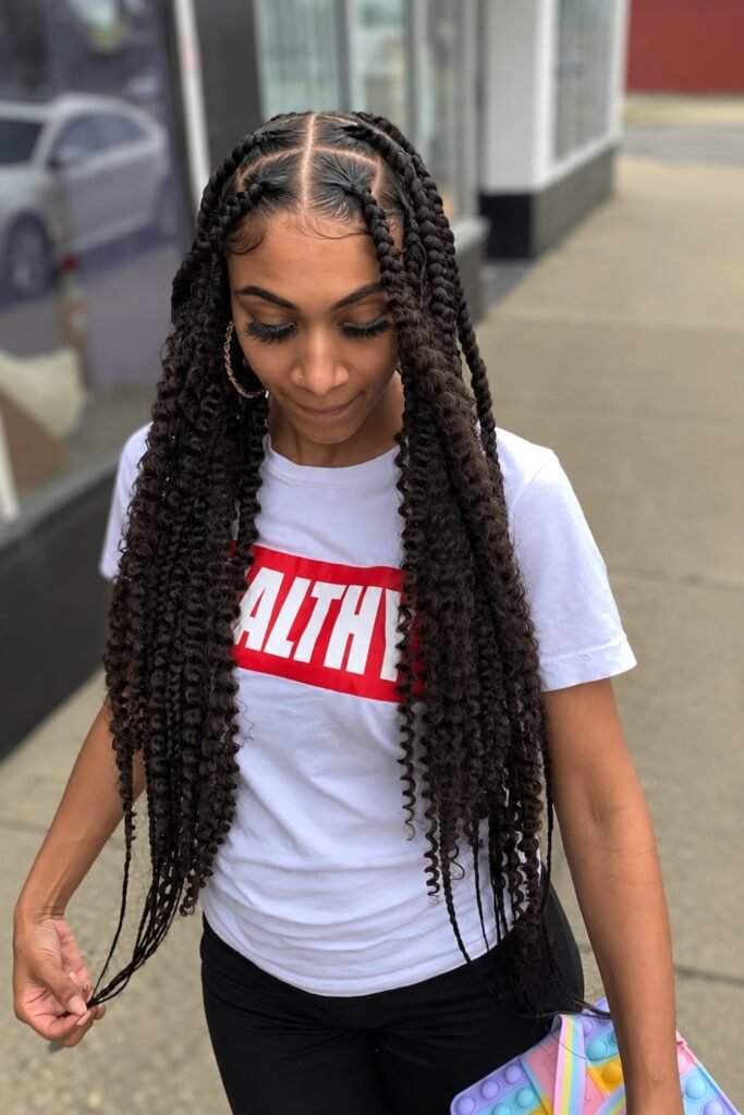 Long center-part goddess braids worn with a white tee