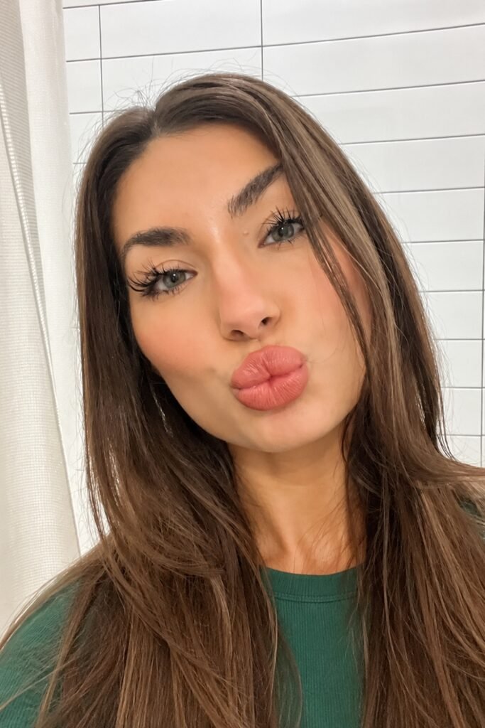Woman with long brown hair wearing chocolate liner and brown gloss