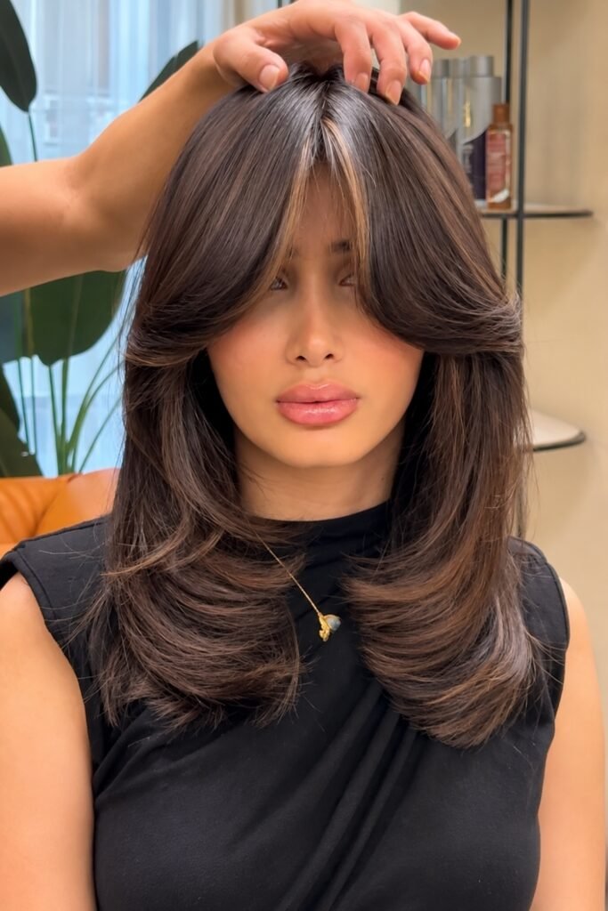 Collarbone-length wavy butterfly cut with a curtain fringe