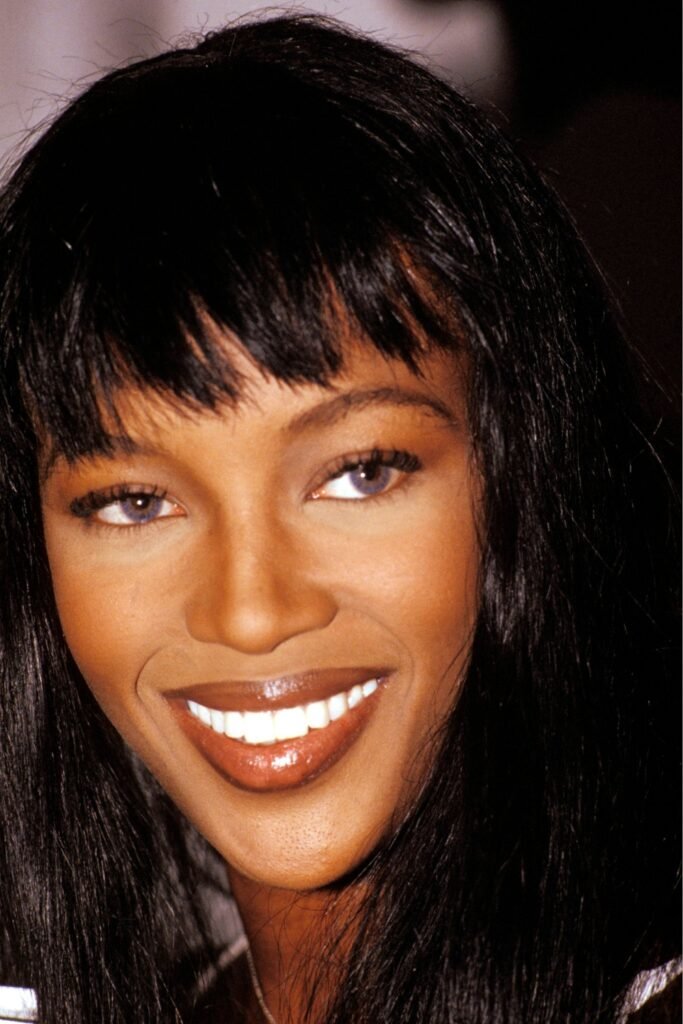Smiling woman with dark brown lip liner and a glossy nude lip