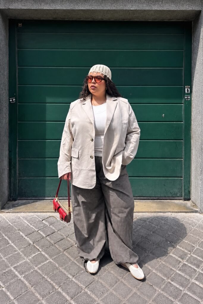 Woman in a crochet hat with a white shirt and wide-leg trousers