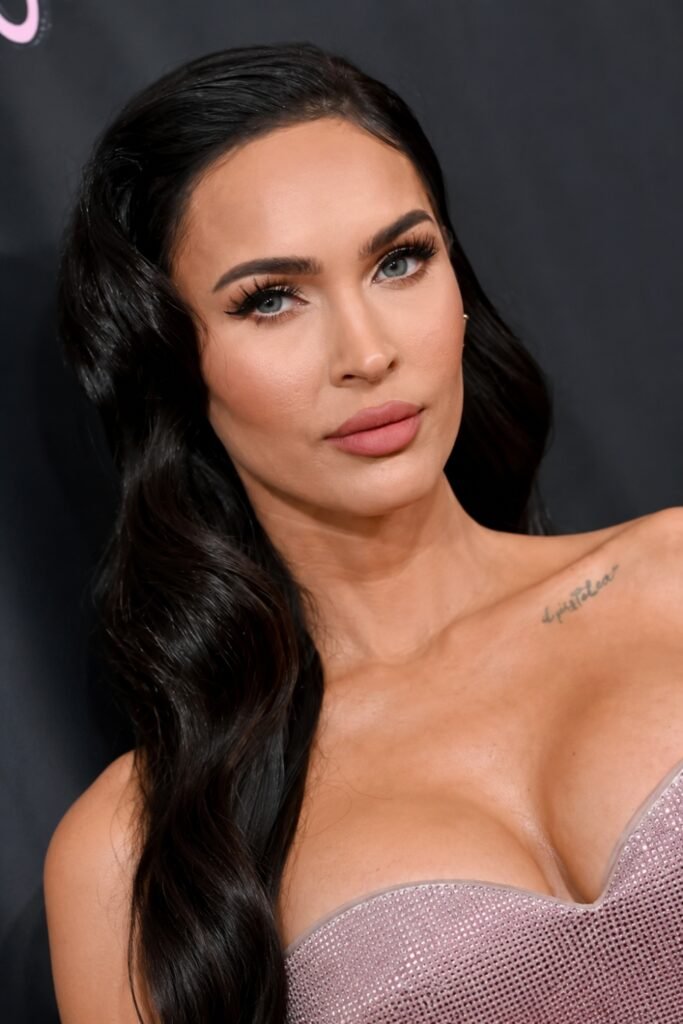Woman with long dark hair wearing deep brown liner and a milky nude gloss