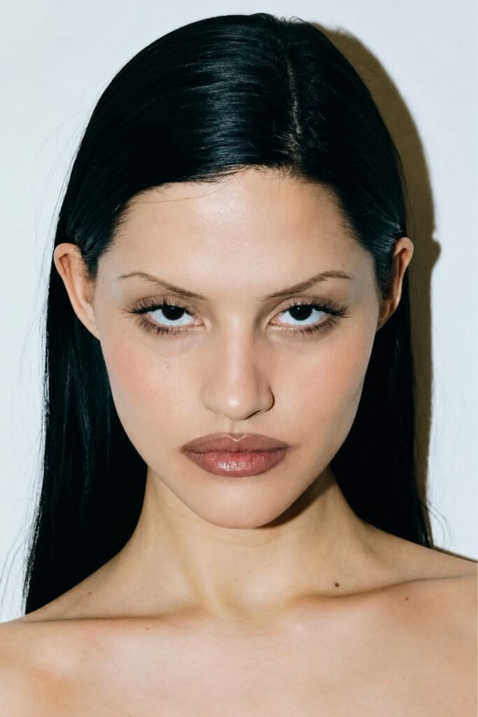 Woman with slicked dark hair wearing espresso liner and a caramel nude lip