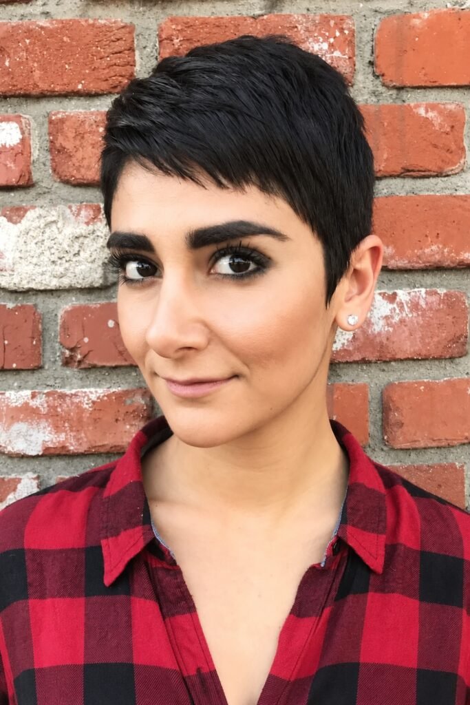 Woman with a short textured tapered cut and a plaid shirt