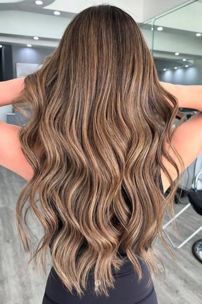 Back view of long wavy hair with caramel and beige balayage