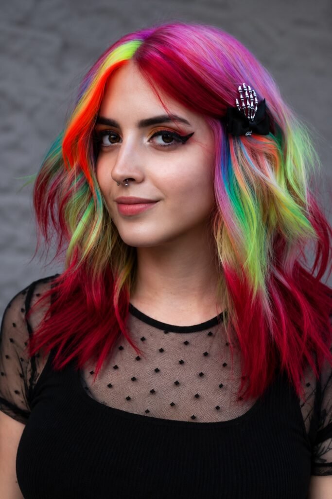 Wavy hair with pink, green, yellow and red sections and a hair clip