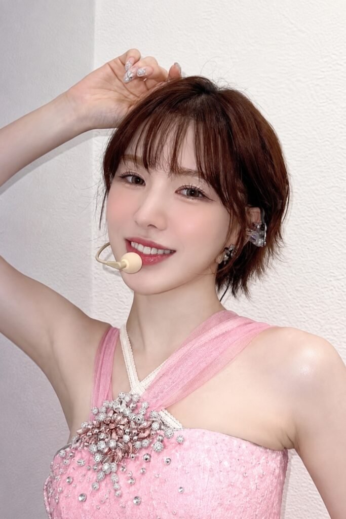 Short layered Wendy cut with a soft fringe, worn with a pink halter top