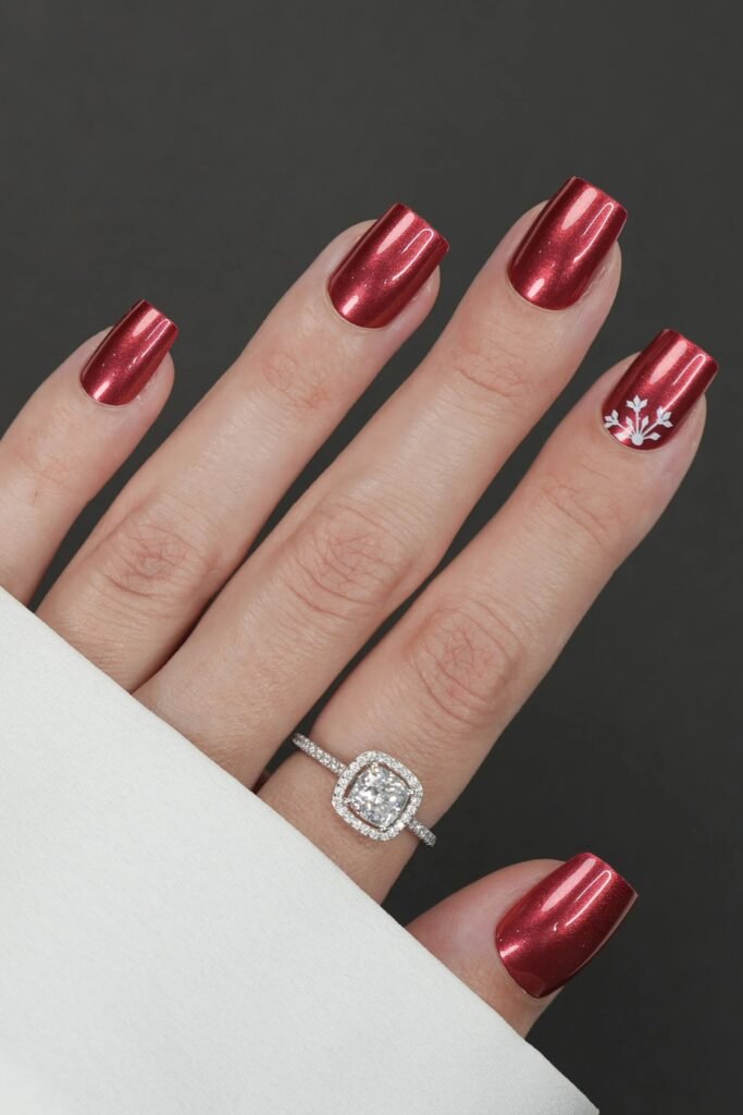 Short square red chrome nails worn with a diamond ring