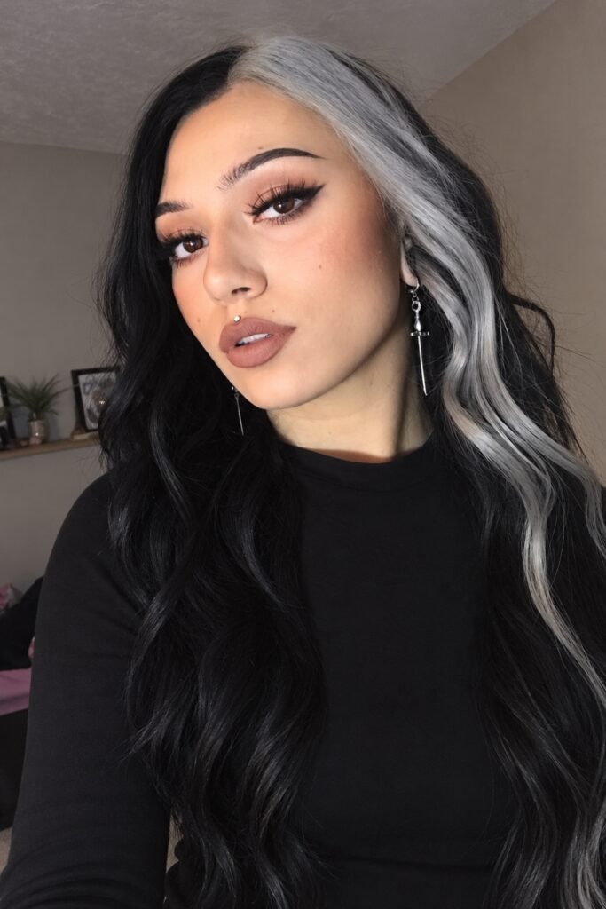 Long black wavy hair with a silver-grey section framing one side of the face