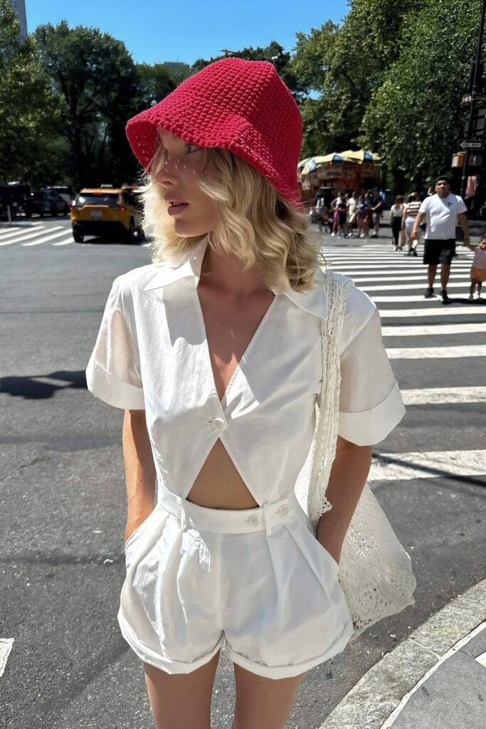 Woman in a red spiral bucket hat with a white linen set
