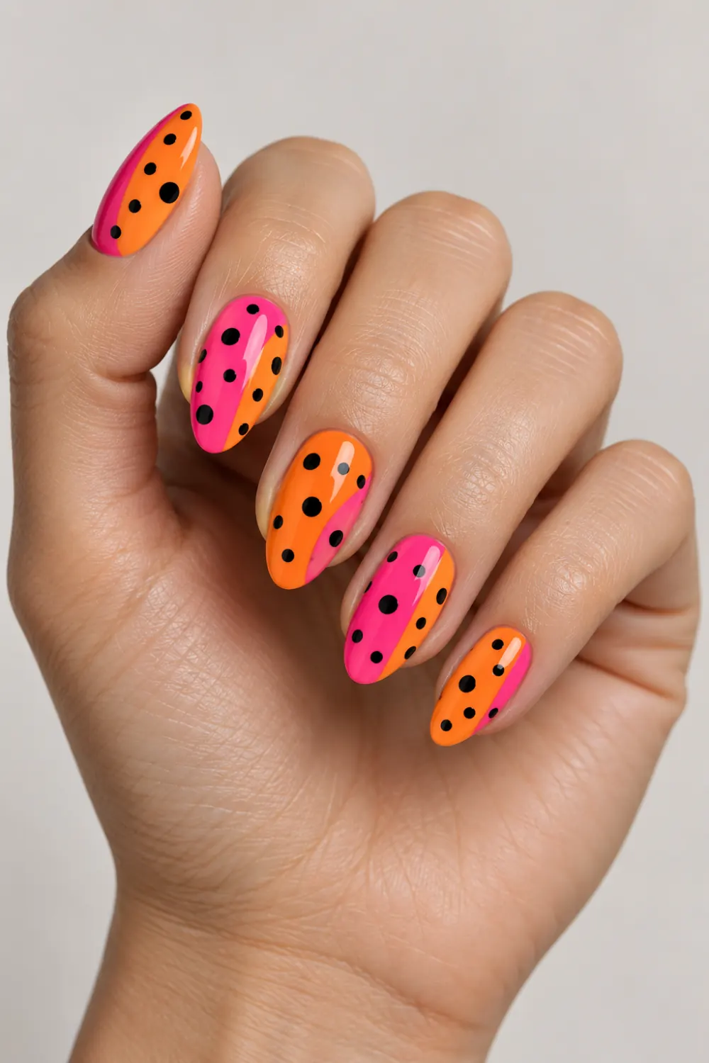 Orange and pink neon nails with ladybird-inspired black dots