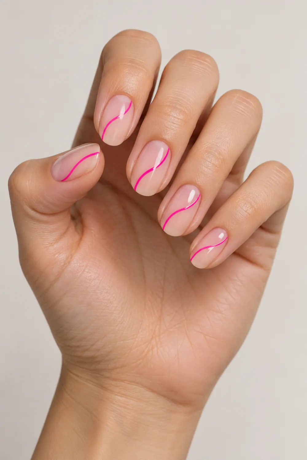 Minimal nude nails with a thin neon pink line