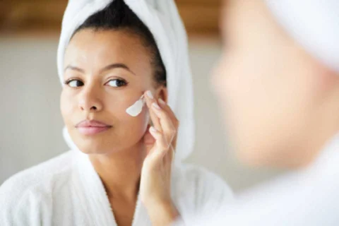 Woman applying skincare cream to her face