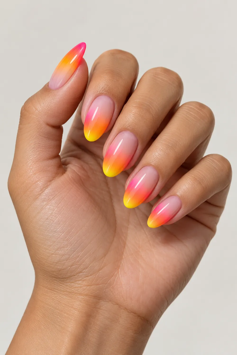 Nude nails fading into neon pink, orange, and yellow tips